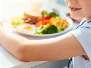 Mężczyzna z pasją ustawia obiektyw zabytkowego aparatu w przytulnej pracowni, co podkreśla twórczy charakter amatorstwa.